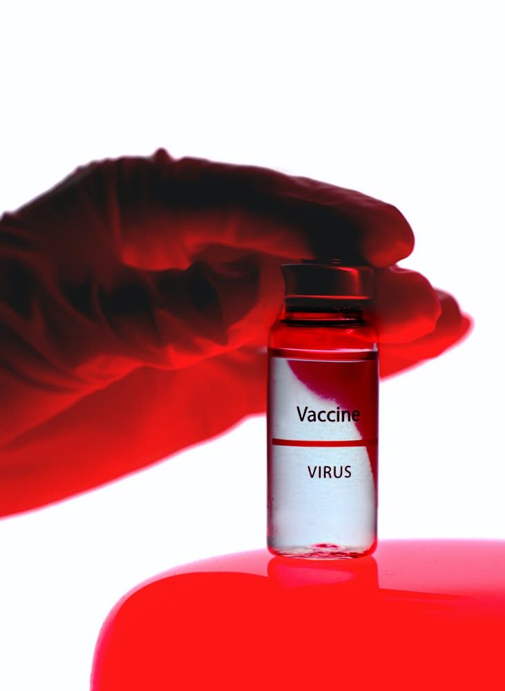 person holding a vaccine vial